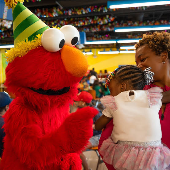 Children celebrating a birthday party with a fun Elmo mascot costume rental creating excitement and memorable moments for guests