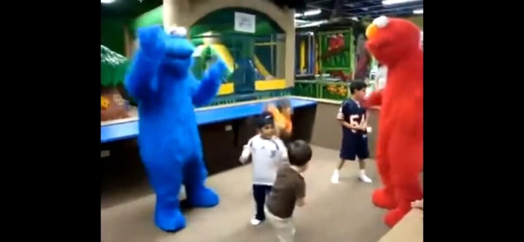 Children smiling and posing with colorful birthday party characters at a Los Angeles kids' birthday celebration.