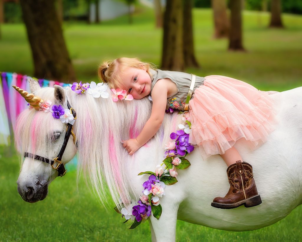 Kids interacting with gentle farm animals during a mobile petting zoo birthday party at an outdoor park.