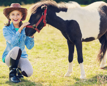 Orange County pony ride and petting zoo birthday party rental with children enjoying a mobile farm animal experience