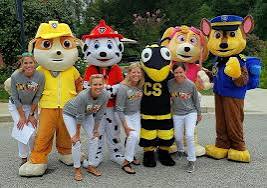 Live Paw Patrol birthday party characters including Chase, Marshall, Skye, Rubble, Rocky, Zuma, Everest, Tracker, and Rex entertaining children at a birthday party.