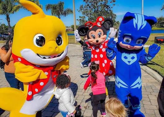 Toddler enjoying fun birthday party entertainment with a friendly mascot character